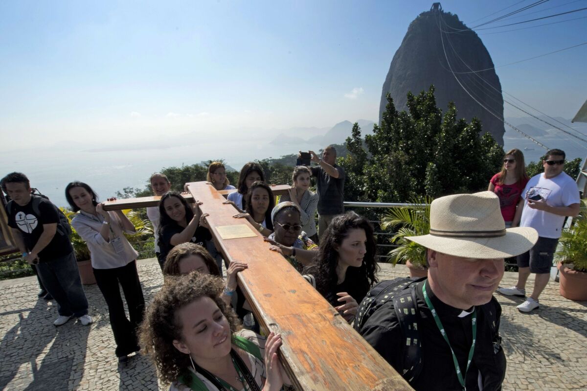 Ahead of Pope Francis' visit, Roman Catholics carry the World Youth Day cross up Sugarloaf Mountain in Rio de Janeiro.