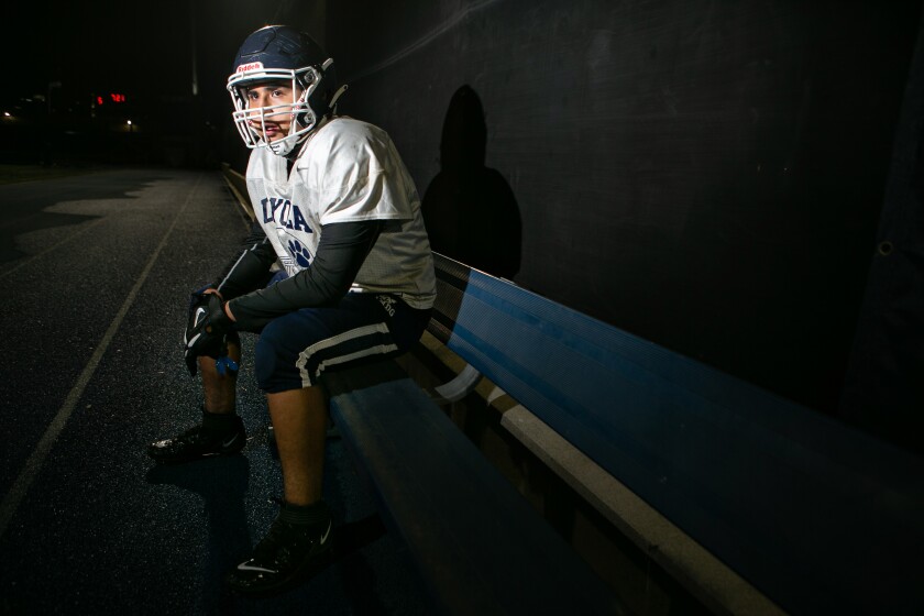 Loyola High lineman Josh Morales sits near a football field.