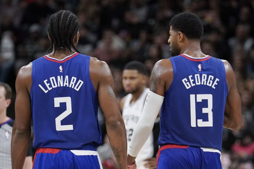 Los Angeles Clippers' Kawhi Leonard (2) and Paul George walk downcourt during the second half of an NBA basketball game against the San Antonio Spurs, Friday, Nov. 29, 2019, in San Antonio. San Antonio won 107-97. (AP Photo/Darren Abate)