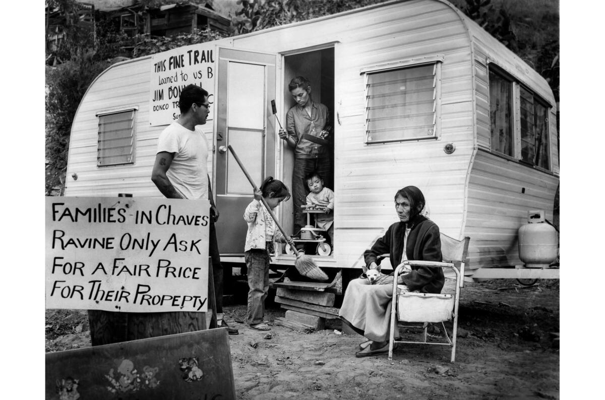 May 13, 1959: After bulldozers destroyed their Chavez Ravine home, Victoria Angustian stands in the doorway of her family's trailer. With her are Manuel Angustian; children Ivy (sweeping) and Ira; and family matriarch Avrana Arechiga.
