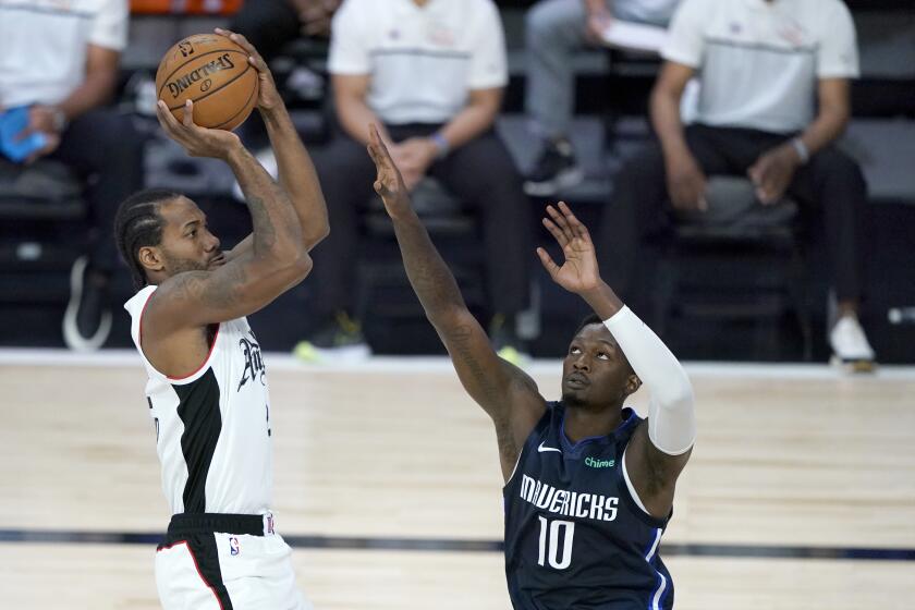 Los Angeles Clippers' Kawhi Leonard, left, goes up for a shot against Dallas Mavericks' Dorian Finney-Smith (10) during the first half of an NBA basketball game Thursday, Aug. 6, 2020 in Lake Buena Vista, Fla. (AP Photo/Ashley Landis, Pool)