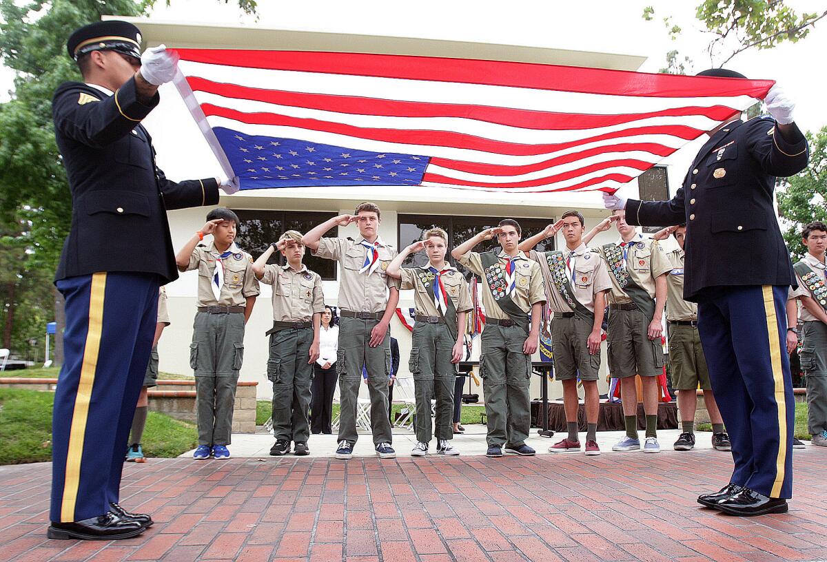 Two representatives from the California State Honor Guard, with Troop 125 Boy Scouts saluting, present an American flag for folding at the Glendale-Montrose-Crescenta Valley Veterans Memorial outside Glendale City Hall on Monday, May 30, 2016. Once folded, the flag will be presented to the Stifter family for their son, who was killed recently in Iraq.