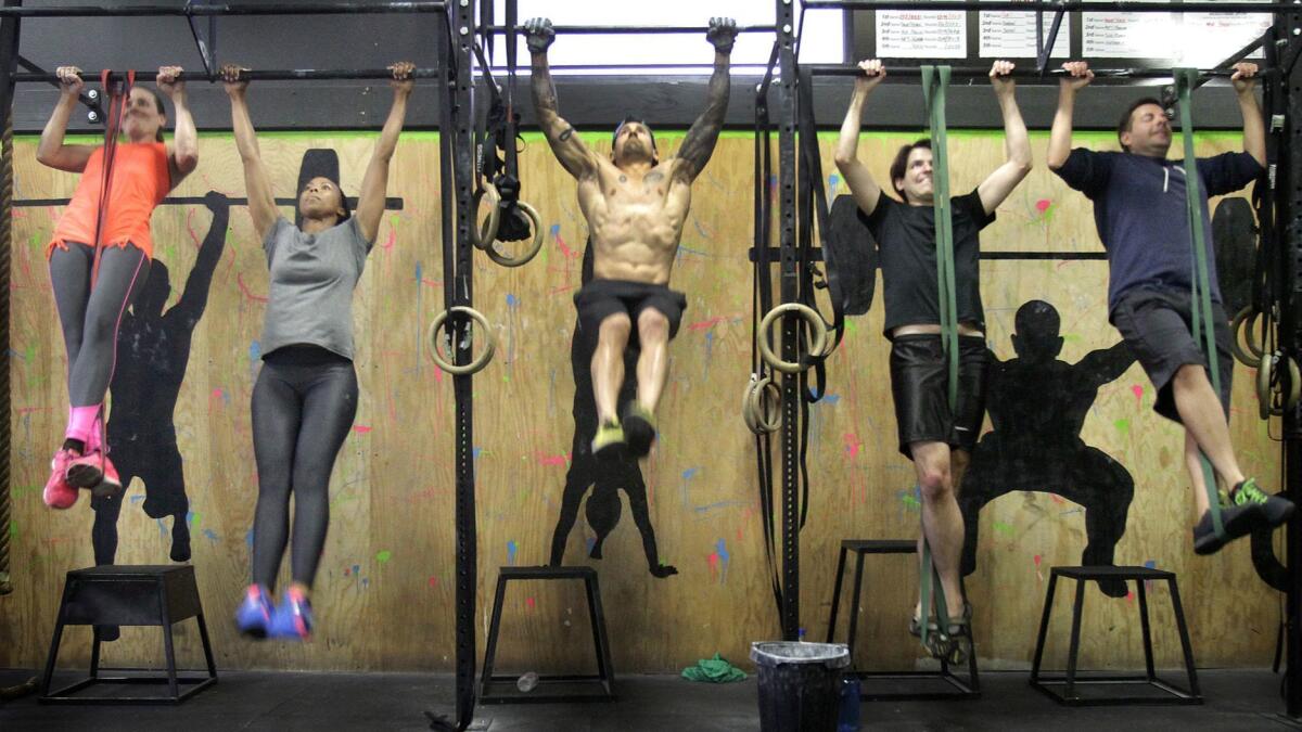 People work out at a Cross-Fit class in Los Angeles. Exercising for at least 30 minutes a day is one of five healthy habits associated with a longer life, new research shows.