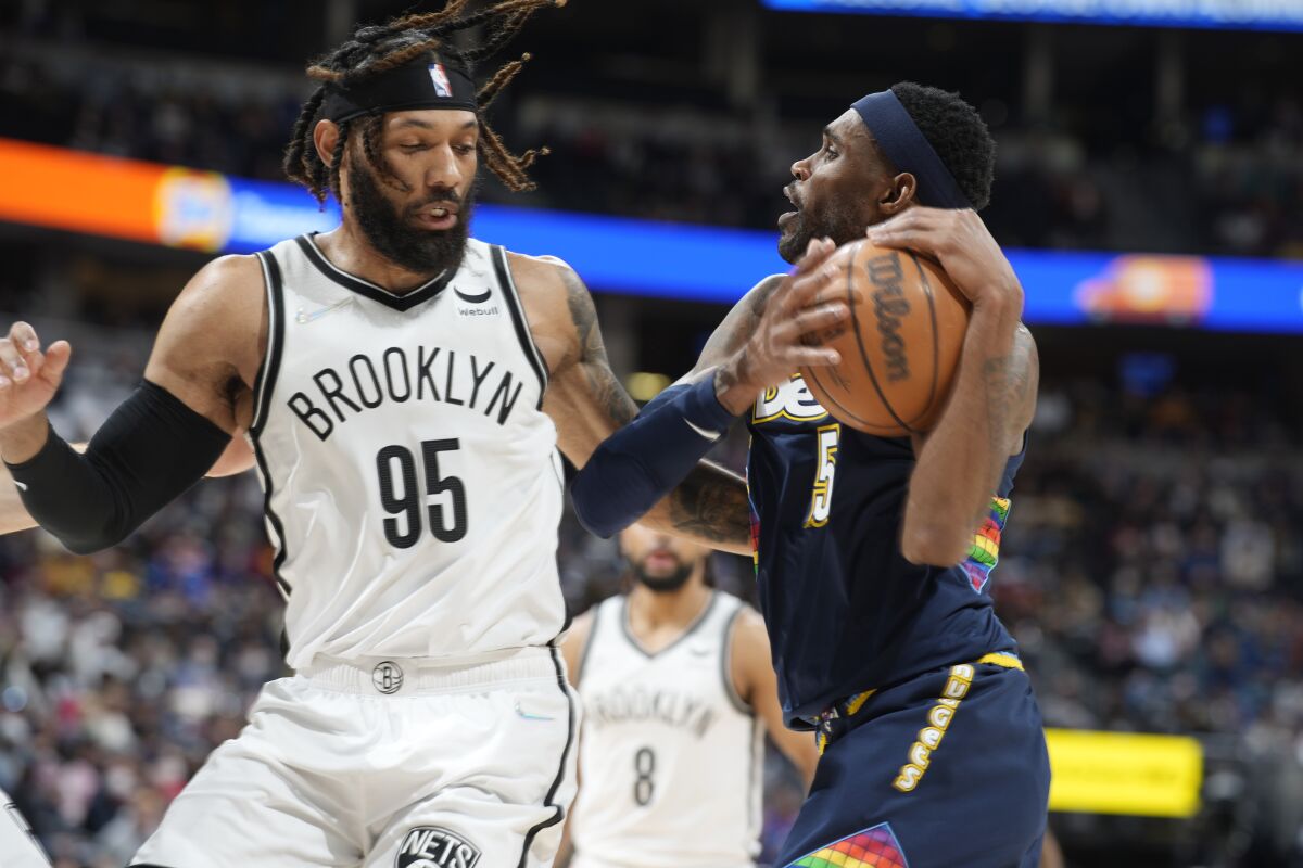 Denver Nuggets forward Will Barton, right, is stopped by Brooklyn Nets (95) guard DeAndre' Bembry while driving to the basket in the second half of an NBA basketball game Sunday, Feb. 6, 2022, in Denver. (AP Photo/David Zalubowski)