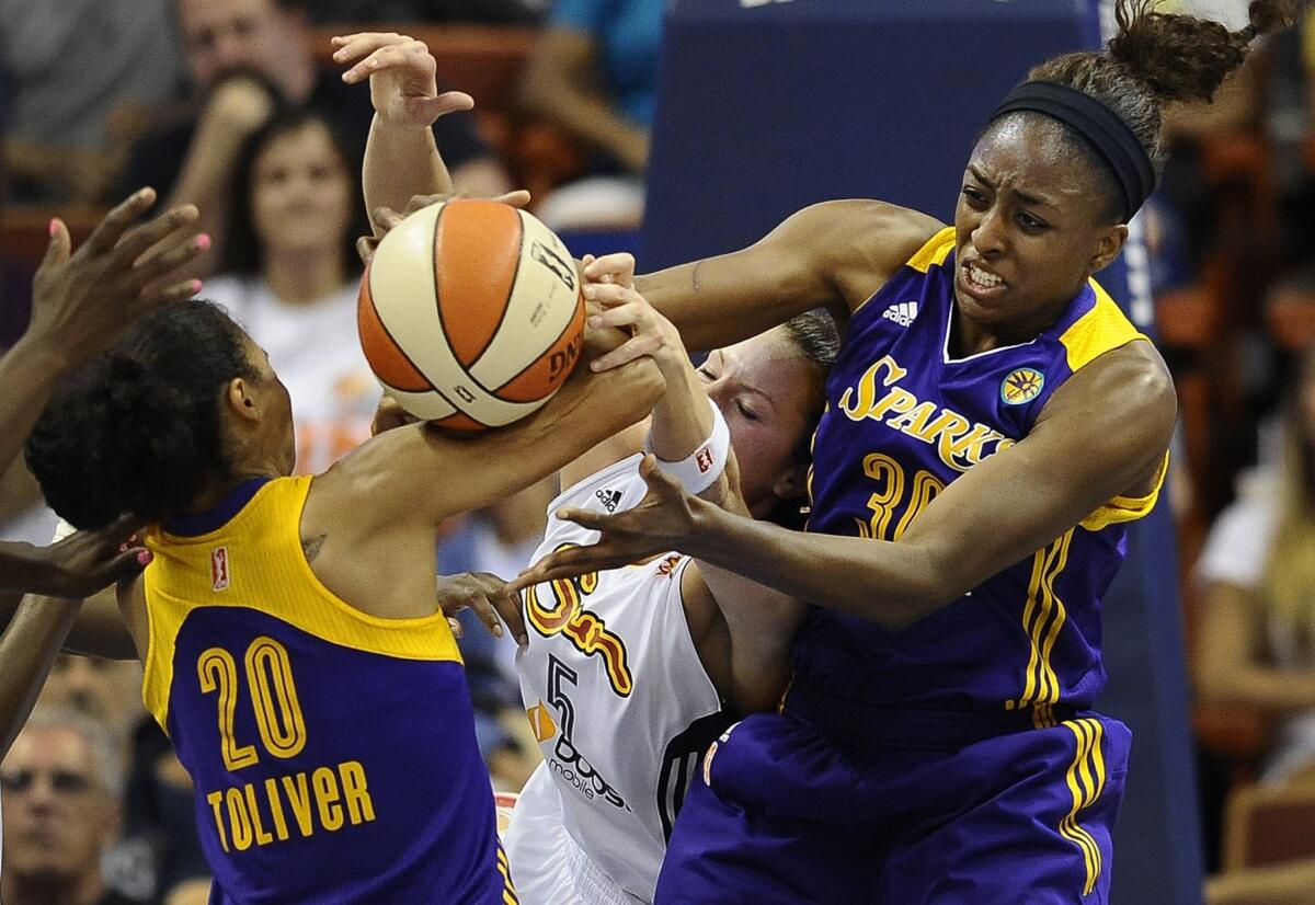 The Sparks' Kristi Toliver, left, and Nneka Ogwumike, right, battle Connecticut's Kelsey Griffin, center, for the ball during the Sparks' 74-72 victory Tuesday.