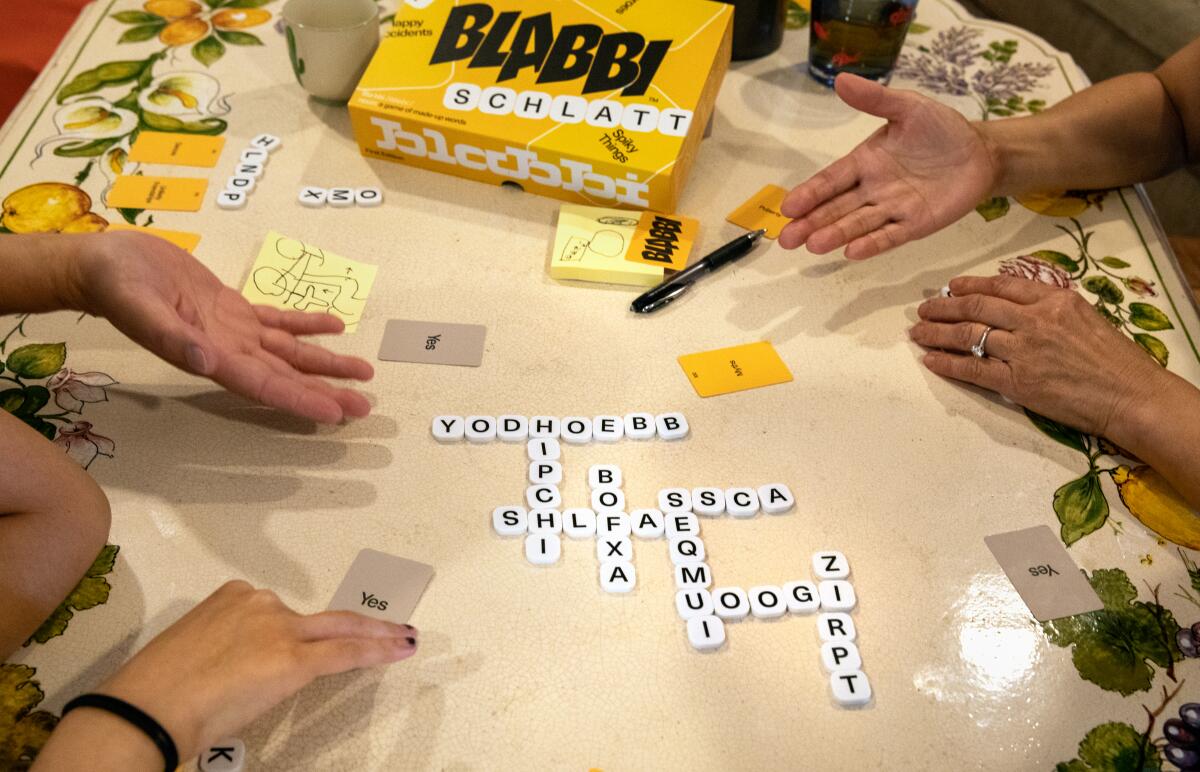White letter tiles are arranged to spell fake words like "hipchi" and "zirpt" on a table.