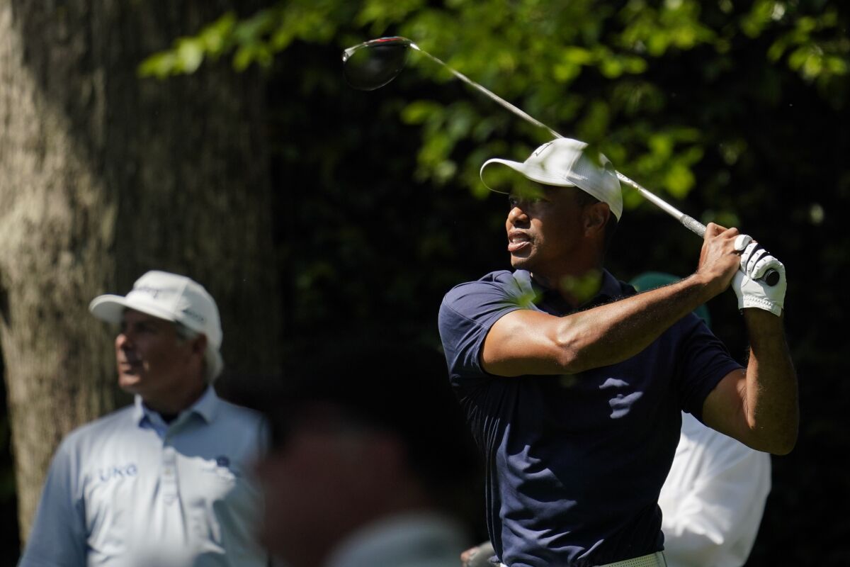 Fred Couples watches as Tiger Woods tees off on the second hole during a practice round for the Masters tournament Monday.