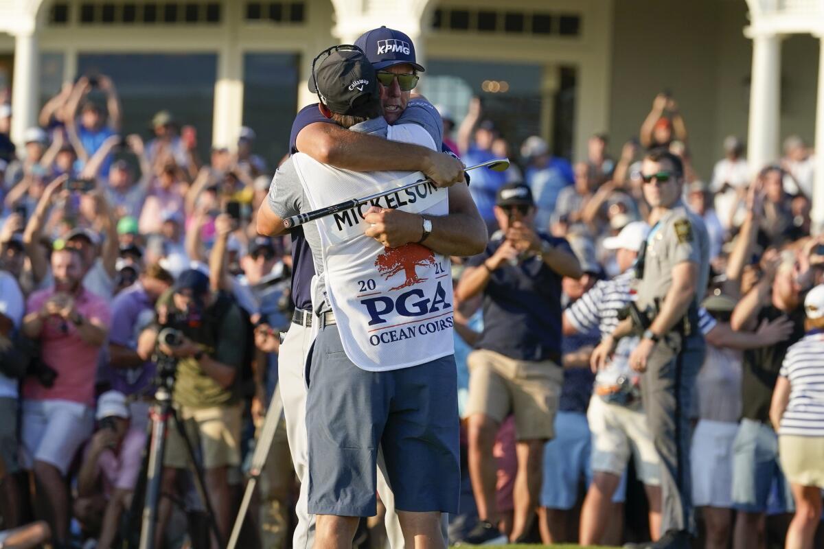 Phil Mickelson hugs his caddie after winning the PGA Championship on Sunday.