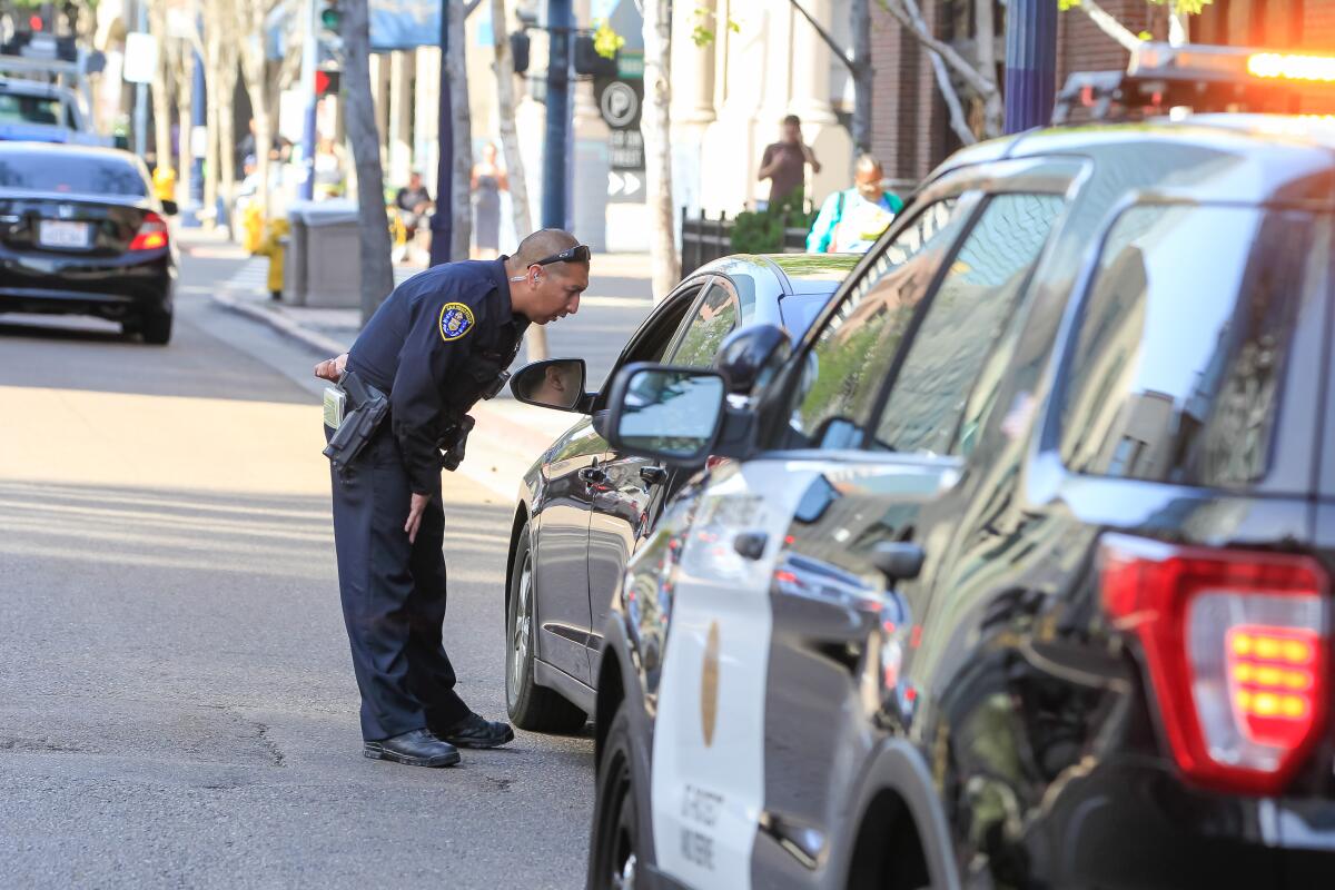 A San Diego police officer pulls over a man at First and Market in Downtown San Diego.