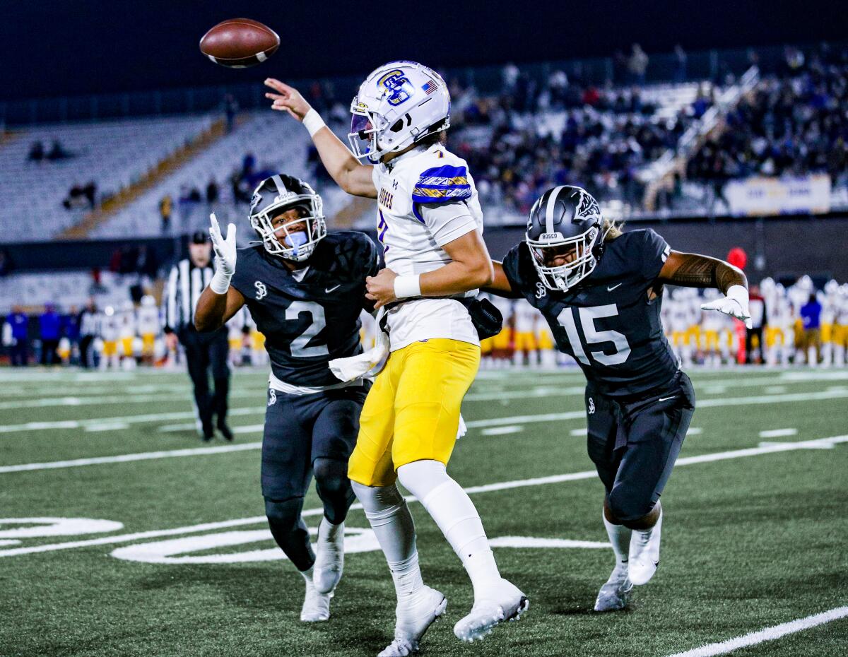 Serra High QB Maealiuaki Smith passes while under pressure from St. John Bosco's Deven Bryant (2) and Jordan Lockhart.