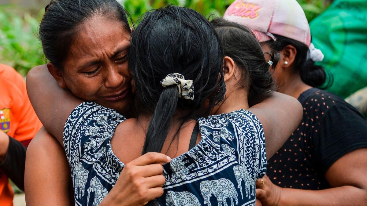 A woman cries when she is reunited with her family amid the rubble left by mudslides in Mocoa, Colombia.