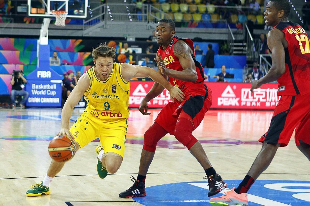 Australia's Matthew Dellavedova tries to drive around Angola's Edson Ndoniema.