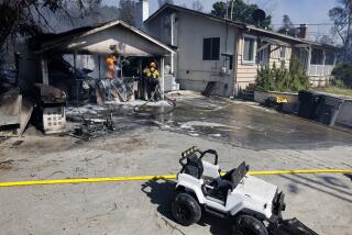 CORONA, CA - JUNE 24: A firefighter works on putting out flames in a garage that caught fire at the Serrano Fire on Monday, June 24, 2024 in Corona, CA.(Gina Ferazzi / Los Angeles Times)