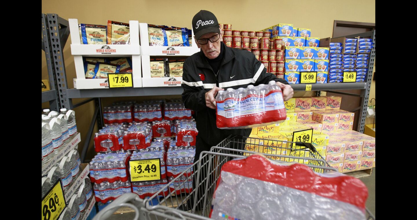 Dave Ross loads up on bottled water, which he'll hand out to homeless people, at the East Village Grocery Outlet.