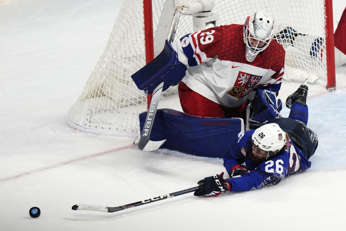 Kendall Coyne Schofield of the U.S. reaches for the puck in front of Czech Republic goalkeeper Klara Peslarova 