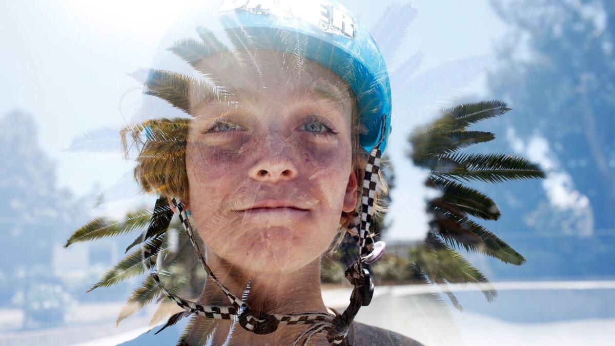 Roscoe Roberts, 11, is framed by a palm tree in this double exposure photograph taken at Poindexter Park.