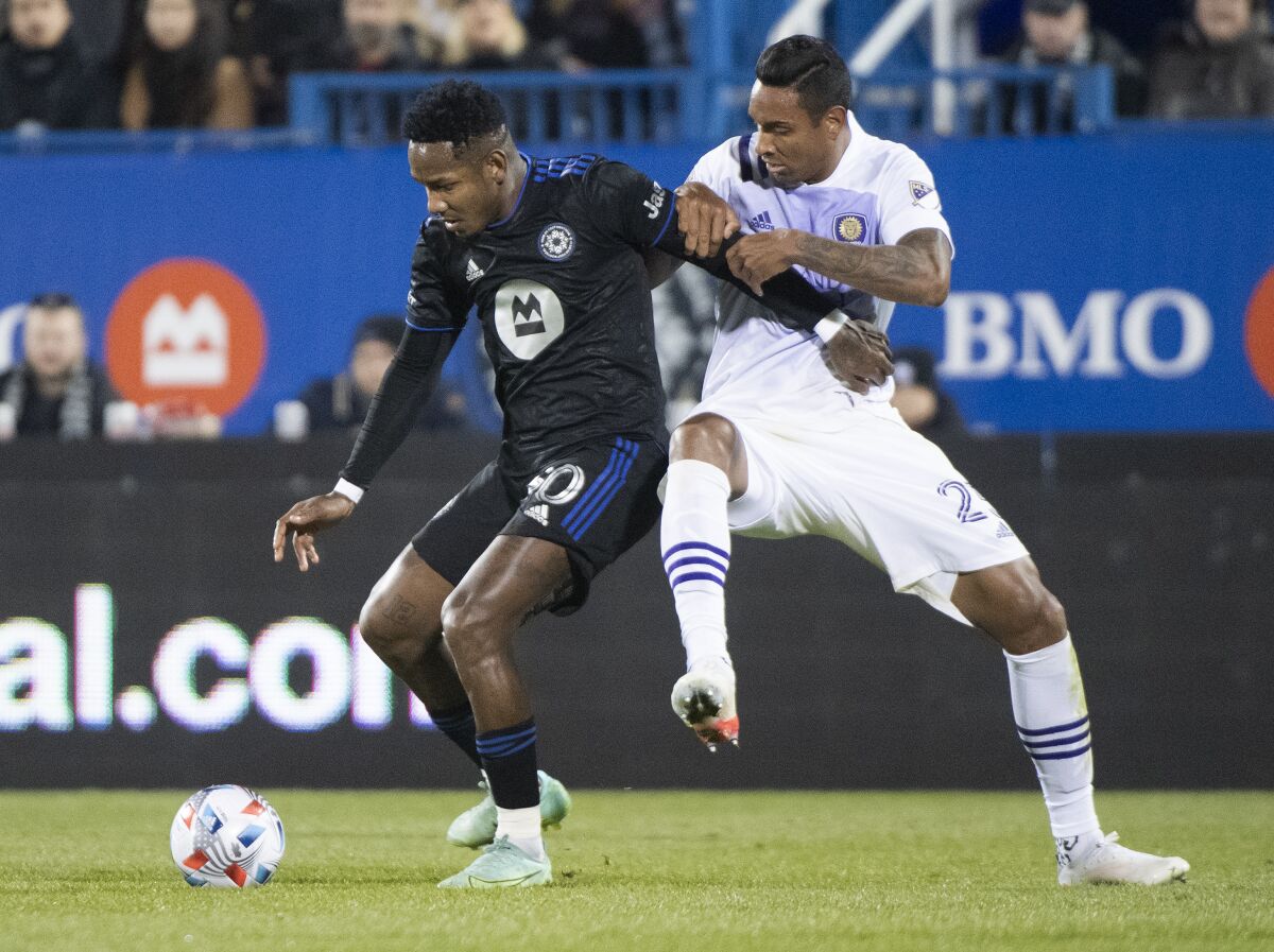 CF Montreal's Romell Quioto, left, challenges Orlando City's Antonio Carlos during second-half MLS soccer match action in Montreal, Sunday, Nov. 7, 2021. (Graham Hughes/The Canadian Press via AP)