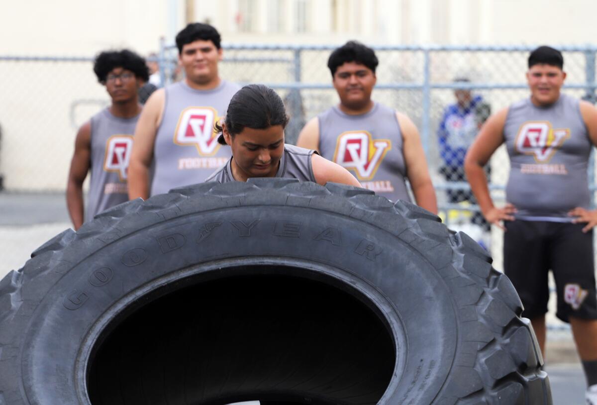 Ocean View lineman Marcello Rivera competes in the tire flipping competition at the Surf City tournament on Saturday.