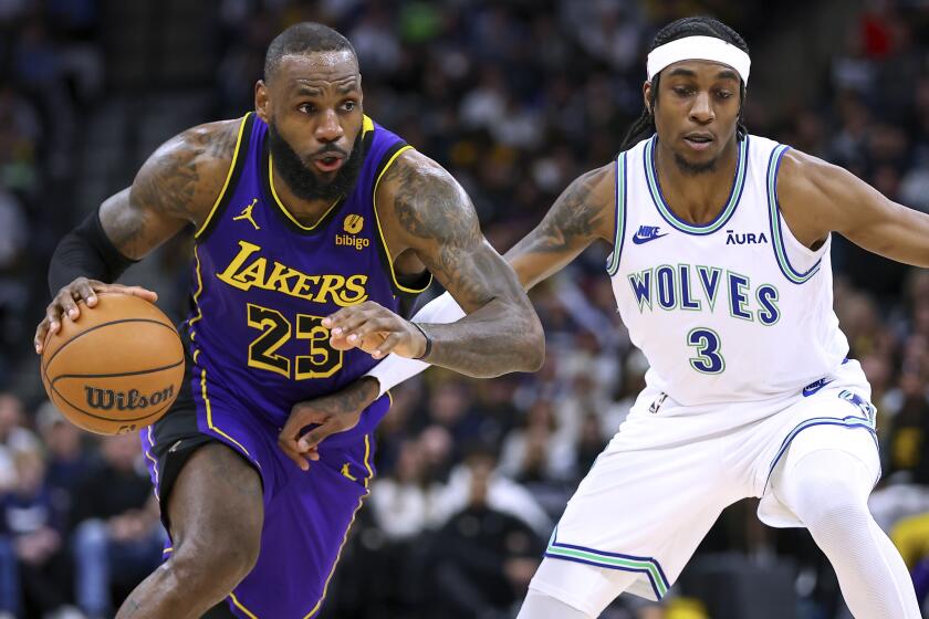 Los Angeles Lakers forward LeBron James, left, works toward the basket as Minnesota Timberwolves.