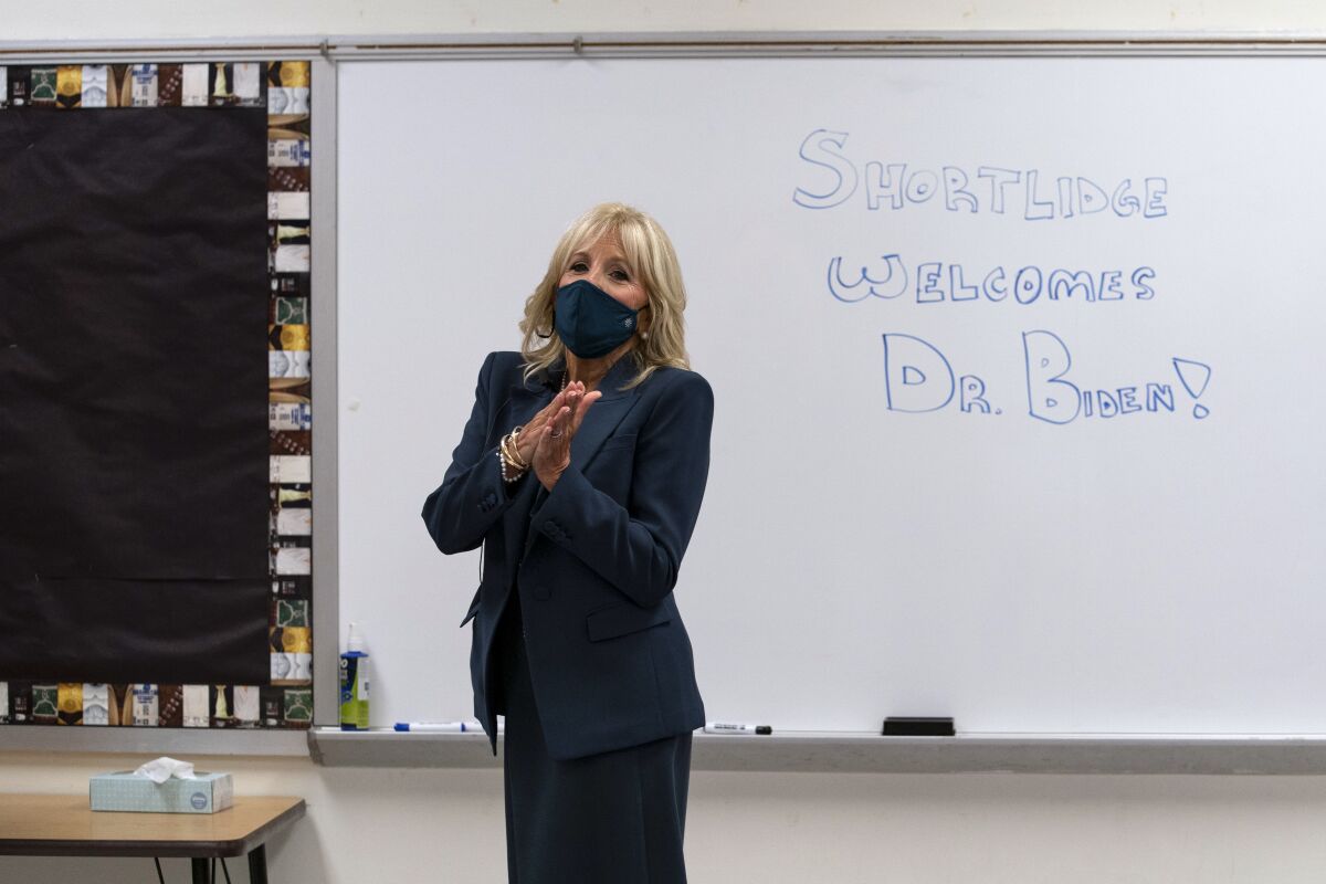 FILE - In this Sept. 1, 2020, file photo Jill Biden, wife of Democratic presidential candidate former Vice President Joe Biden, walks past a dry erase board in a classroom that reads "Shortlidge Welcomes Dr. Biden," as she tours the Evan G. Shortlidge Academy in Wilmington, Del. In an election year where reopening schools shuttered by the coronavirus pandemic is emerging as a flashpoint, Jill Biden is increasingly drawing on her experience in the classroom to empathize with parents struggling to cope with the shift to virtual learning. (AP Photo/Carolyn Kaster, File)