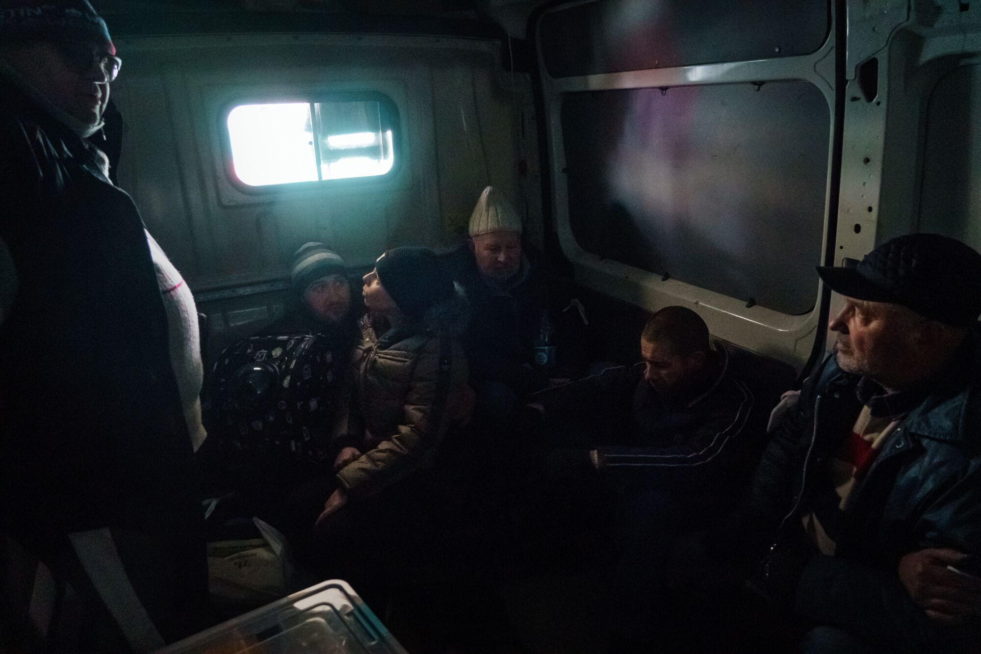 Residents riding in the back of a darkened van