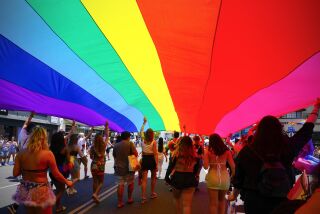 San Diego, CA - July 16: Parade participants march down the parade route on Saturday, July 16, 2022 in San Diego, CA., proudly displaying the Pride flag during San Diego Pride 2022. (Nelvin C. Cepeda / The San Diego Union-Tribune)