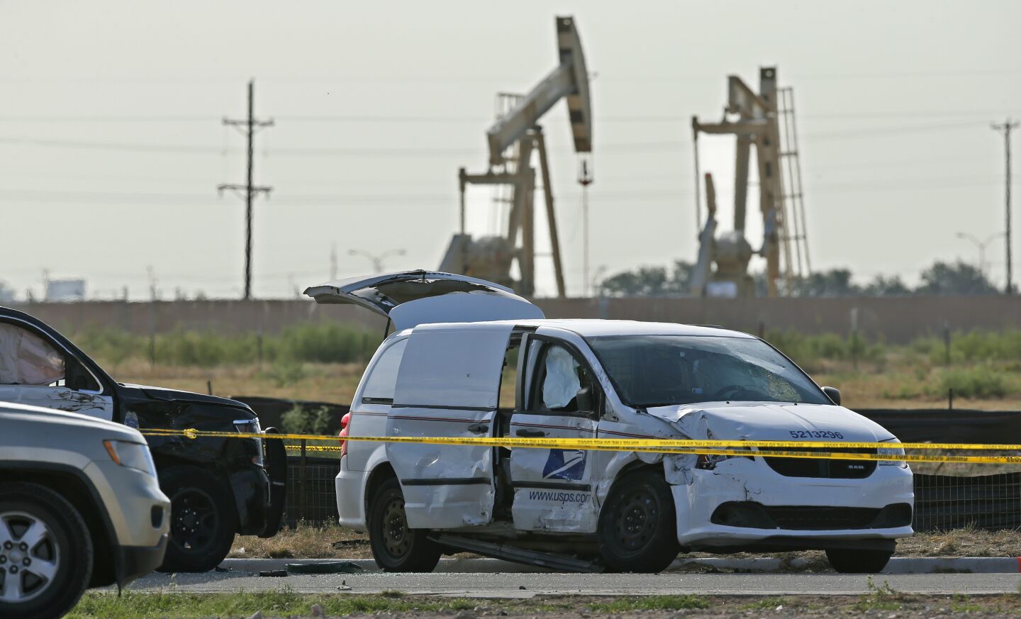 A U.S. Mail vehicle, right, which was involved in Saturday's shooting, is pictured outside the Cinergy entertainment center Sunday, Sept. 1, 2019, in Odessa, Texas. The death toll in the West Texas shooting rampage increased Sunday as authorities investigated why a man stopped by state troopers for failing to signal a left turn opened fire on them and fled, shooting over a dozen people as he drove before being killed by officers outside a movie theater. A police vehicle is partially blocked at left. (AP Photo/Sue Ogrocki)