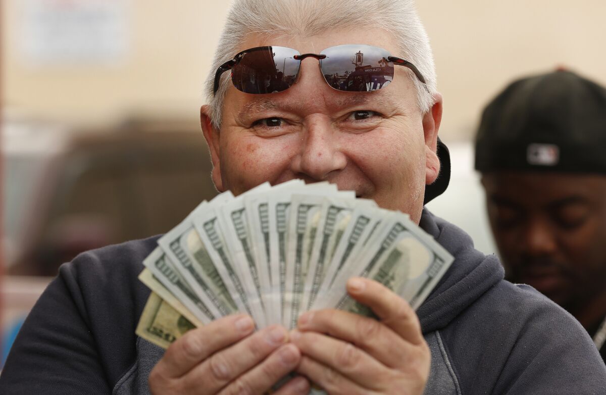 Richard Litton of Playa Del Rey holds $3,000 to purchase 1,500 Powerball tickets in Hawthorne. The California Lottery funnels $1.7 billion to California's K-12, colleges and universities which covers only about 1.5% of the state’s total education budget.