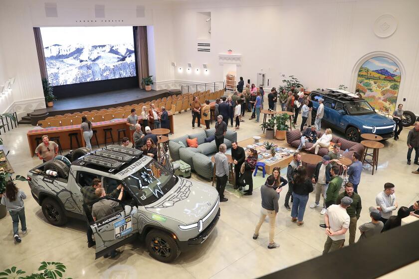 Guests enjoy a look of a new showroom and theater of the new Rivian South Coast Theater during dedication of grand opening on Friday in Laguna Beach.