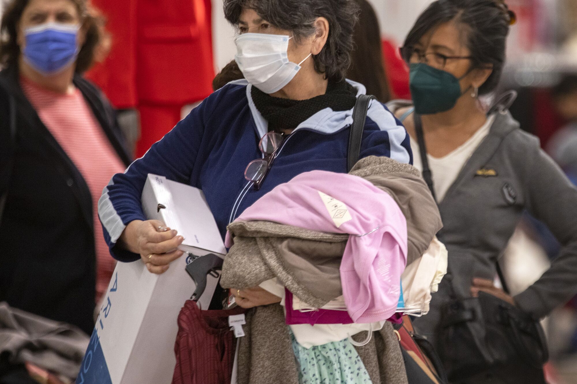 Loaded with merchandise, customers wait in line to pay for their goods at JCPenney at the Glendale Galleria.