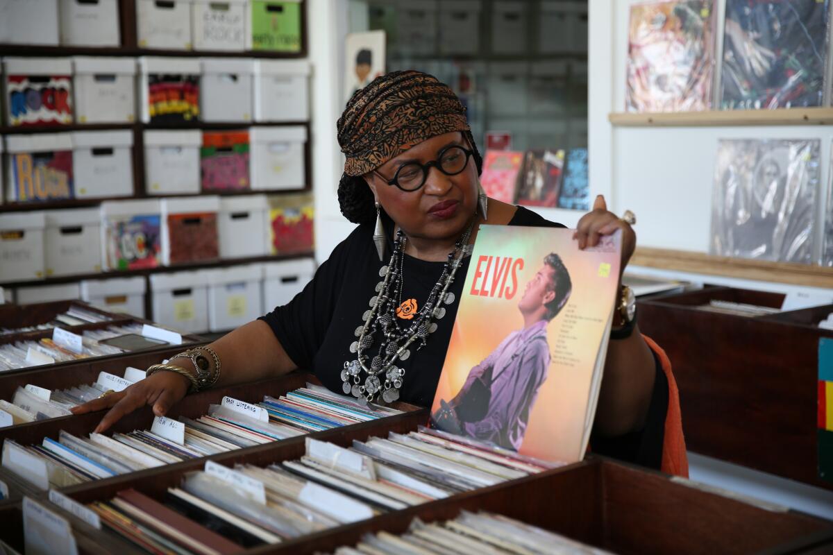 A woman holds up an Elvis album