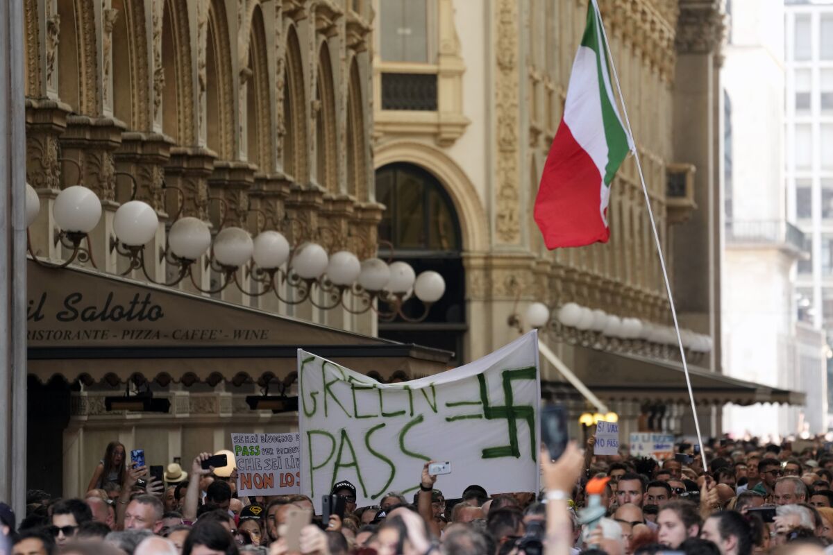 People stage a protest against the "green pass" in Milan, Italy, Saturday, July 24, 2021. Police conducted searches across Italy on Monday, Nov. 15, 202 against 17 anti-vaccine activists who were affiliated with a Telegram chat that espoused violence against government, medical and media figures for their perceived support of COVID-19 restrictions. Police in Turin said the "Basta Dittatura" (Enough of the Dictatorship) chat had tens of thousands of members and was a prime forum for organizing protests against Italy's health pass, which shows proof of vaccination, a recent negative test or having been cured of COVID-19. (AP Photo/Antonio Calanni, File)
