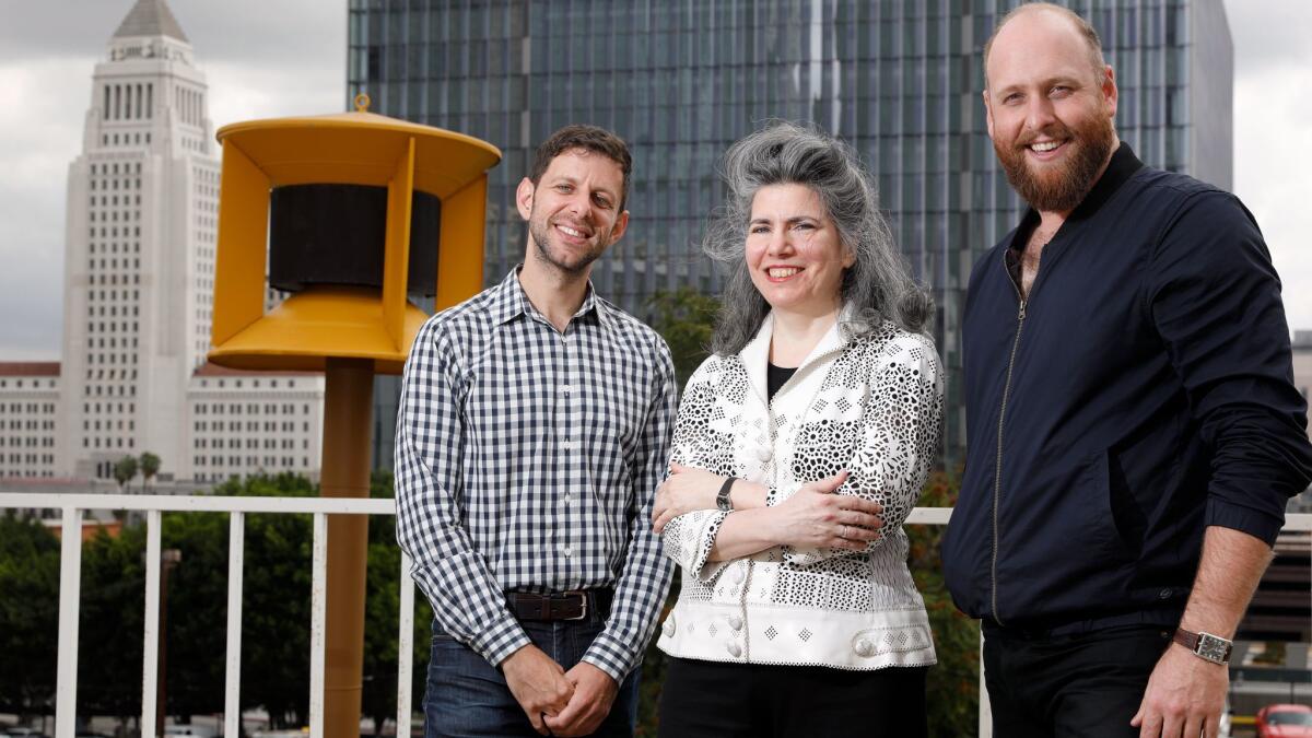 "War of the Worlds" director Yuval Sharon, left, composer Annie Gosfield and conductor Christopher Rountree by one of the vintage air-raid sirens to be used in the Los Angeles Philharmonic's adaptation of Orson Welles' 1938 broadcast about aliens invading Earth.