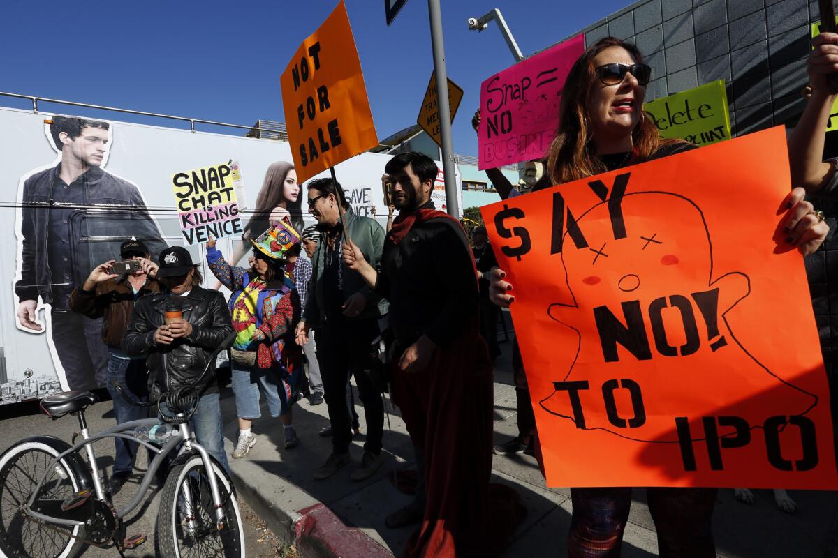 Danielle Mitchell, right, joins her fellow Venice residents, business owners, artists and landlords in a protest in front of the "Snapchat Campus" on Market Street in Venice on Feb. 28, 2017. Local residents and community groups are upset with Snapchat for what they believe is the co-opting of Venice landmarks and rendering them private and turning beachfront residential properties into office space which they say is a violation of zoning regulations.