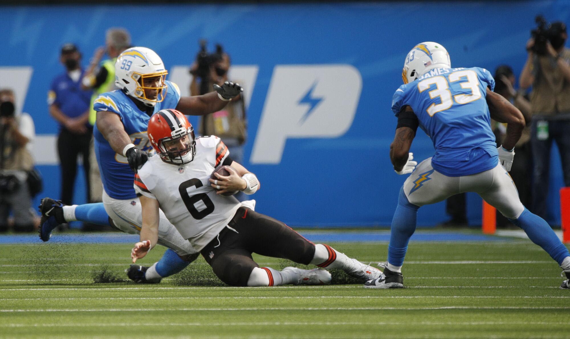 Cleveland Browns quarterback Baker Mayfield slides on the turf to avoid being tackled.