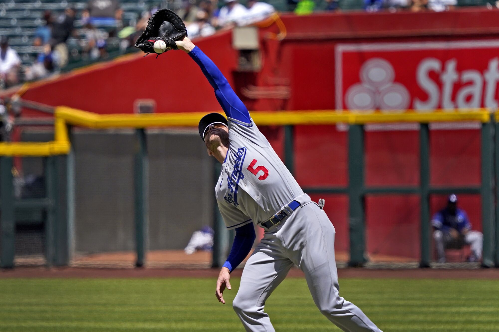 Dodgers first baseman Freddie Freeman loses a pop-up hit by Arizona Diamondbacks' Daulton Varsho in the sun.