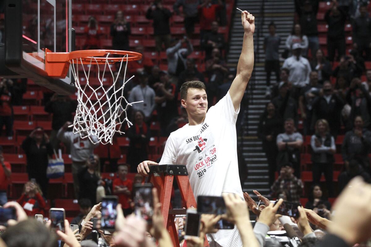 SDSU's Yanni Wetzell celebrates with net cutting after the Aztecs defeated New Mexico at Viejas Arena on Feb. 11.