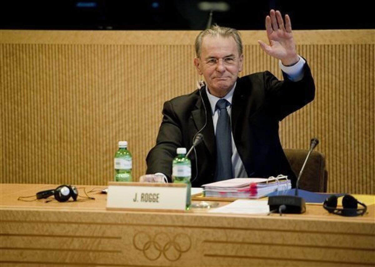 International Olympic Committee, IOC, President Belgian Jacques Rogge raises his arm prior to the opening of the executive board's meeting, at the IOC headquarters in Lausanne, Switzerland, Wednesday, Dec. 7, 2011. (AP Photo/dapd//Jean-Christophe Bott)