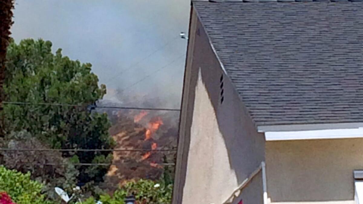 A brush fire burns close to homes in Burbank on Wednesday.
