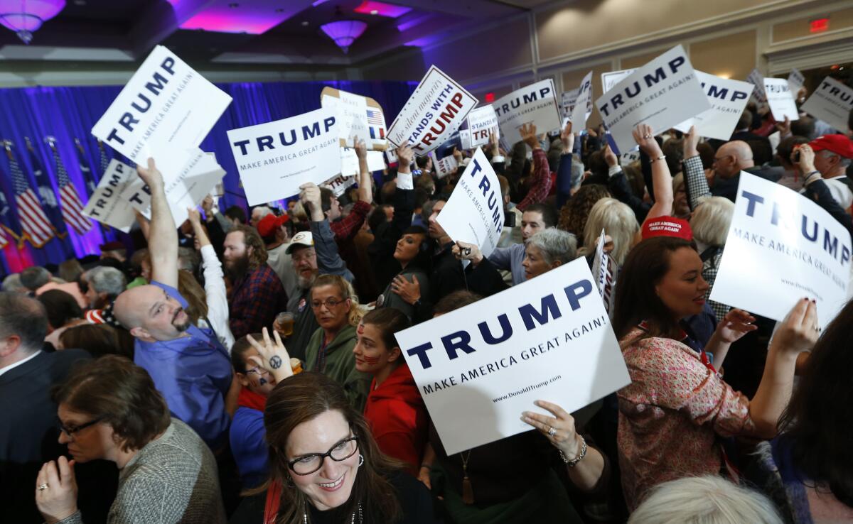 Los partidarios del aspirante a la candidatura presidencial republicana Donald Trump sostienen letreros sobre el multimillonario durante un acto relacionado con las elecciones primarias republicanas en Spartanburg, South Carolina.