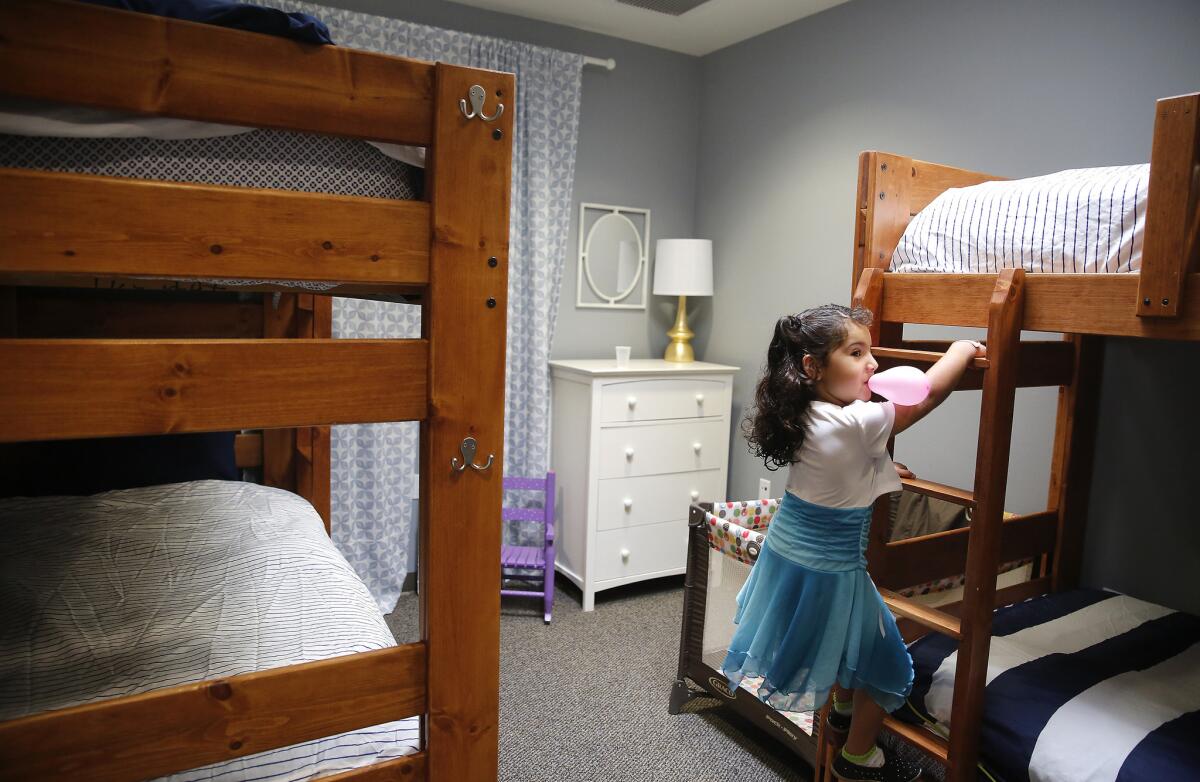 Emily Tsaturyan, 4, climbs a bunk bed ladder in a bedroom at the new San Fernando Valley Rescue Mission.