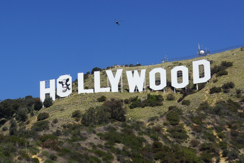 Three men were arrested after the image of a cow was hung over one of the letters of the Hollywood sign.