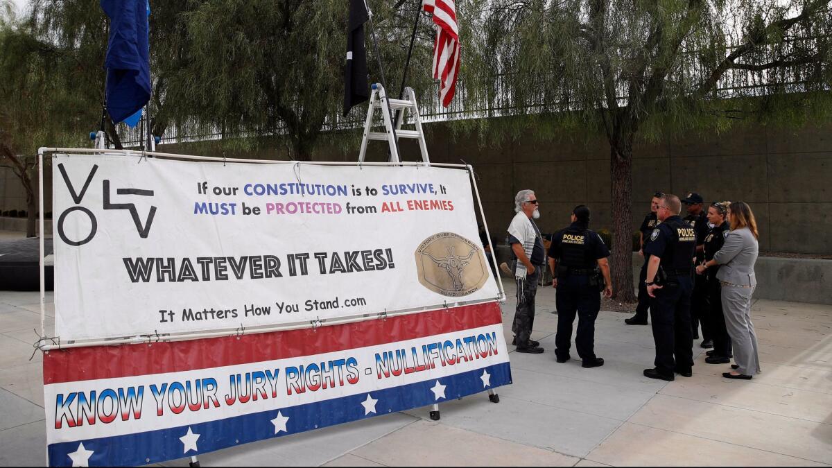 Police officers talk to a supporter of Nevada rancher Cliven Bundy outside federal court in Las Vegas last month.