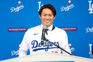 Yoshinobu Yamamoto smiles while addressing media during his introductory Dodgers news conference