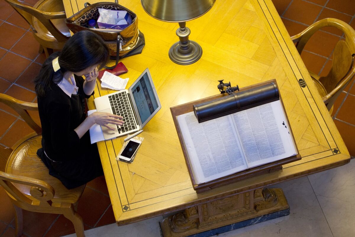 A woman works on her laptop in the Rose Main Reading Room of the New York Public Library this month.