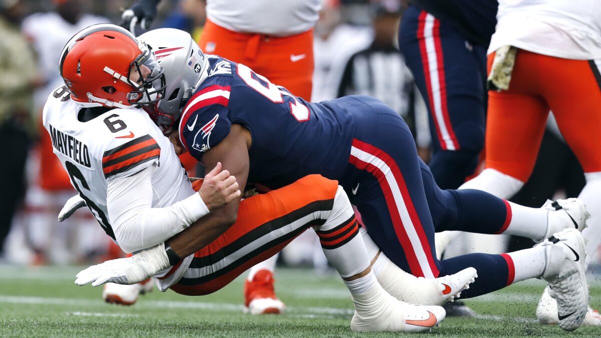 Cleveland Browns quarterback Baker Mayfield (6) gets dropped to the turf by New England Patriots defensive end Deatrich Wise (91) during the second half of an NFL football game, Sunday, Nov. 14, 2021, in Foxborough, Mass. (AP Photo/Michael Dwyer)