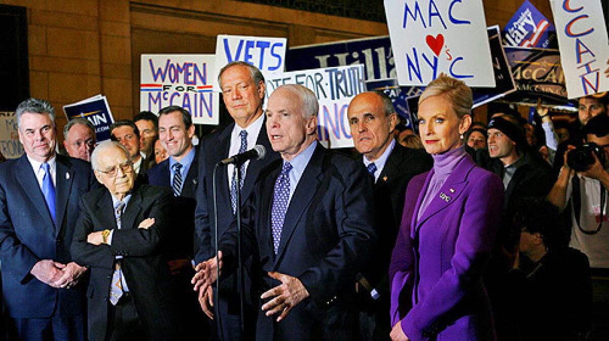 New York State Republicans, left, including former New York Governor George Pataki, fourth from left, and former New York Mayor Rudy Giuliani, second from right, listen as Republican presidential hopeful Sen. John McCain, R-Ariz., center, speaks to reporters with supporters behind him at Grand Central Terminal in New York.