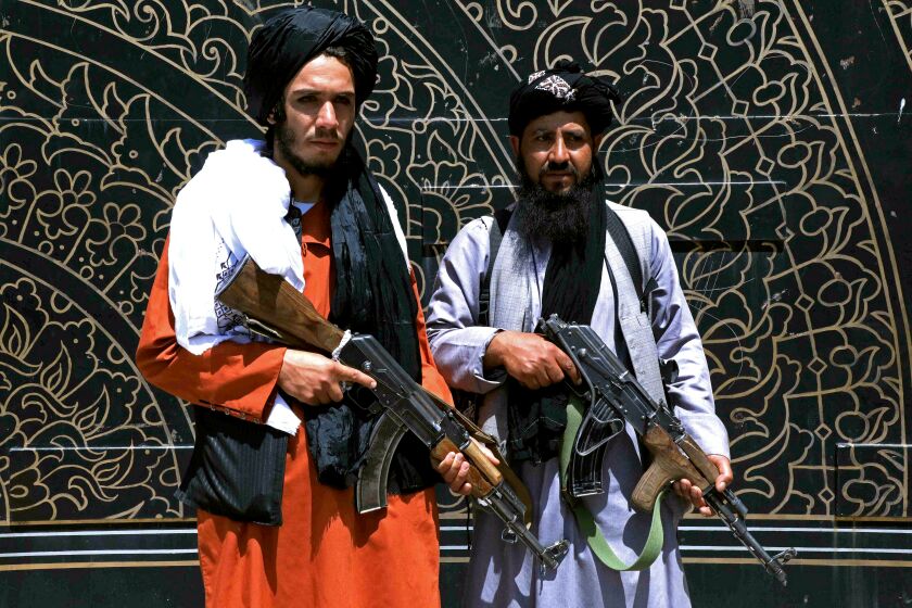 Taliban fighters stand guard in front of the provincial governor's office in Herat on August 14, 2021.