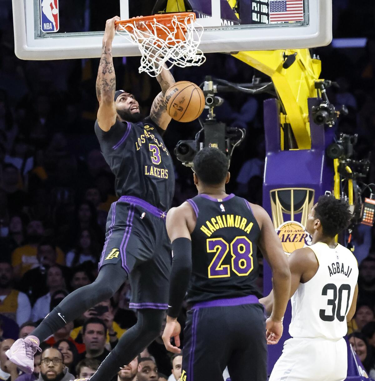 Anthony Davis dunks in front of Lakers teammate Rui Hachimura and the Jazz's Ochai Agbaji.