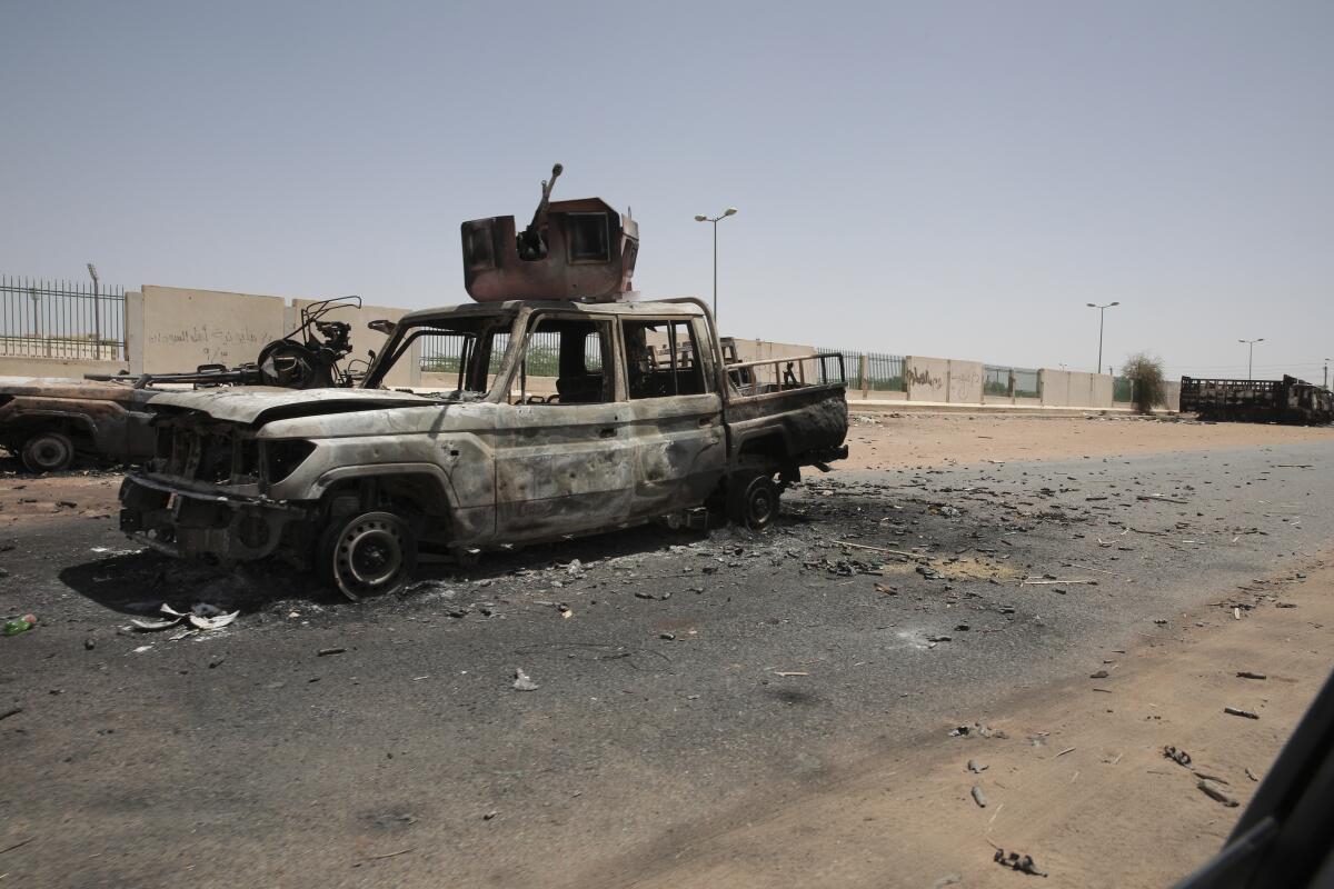 Vehículos militares yacen destrozados el jueves 20 de abril de 2023, en el sur de Jartum, Sudán.